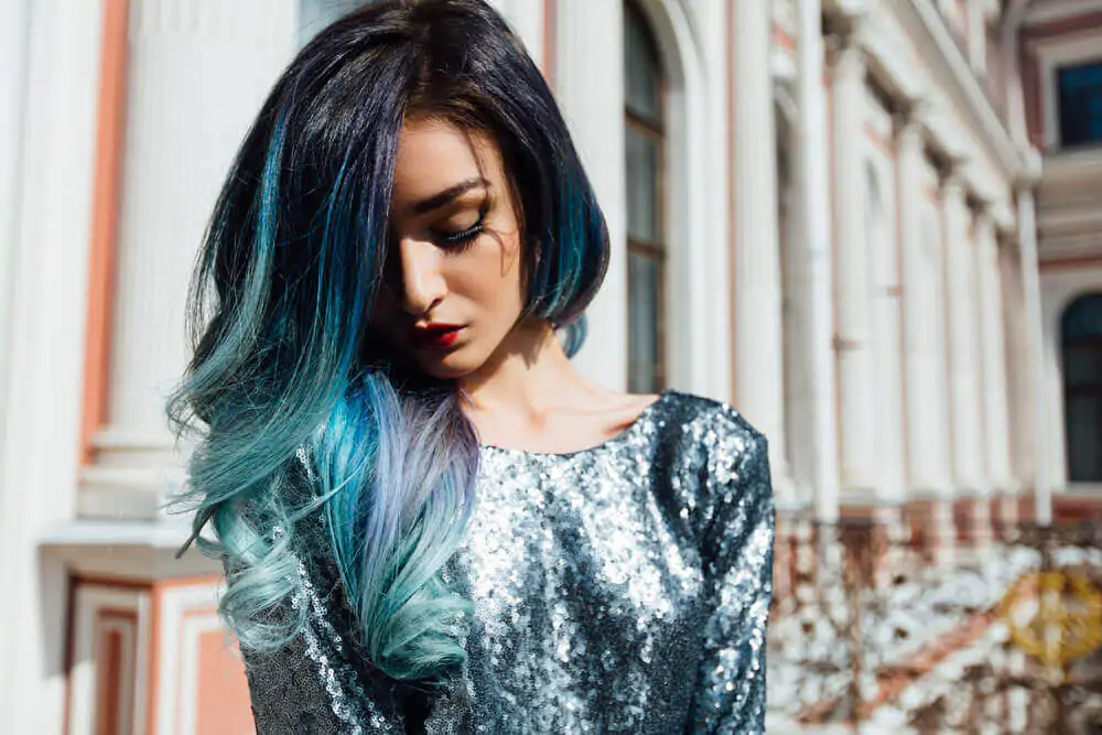 Moda ritratto di una splendida ragazza con lunghi capelli ricci tinti di blu